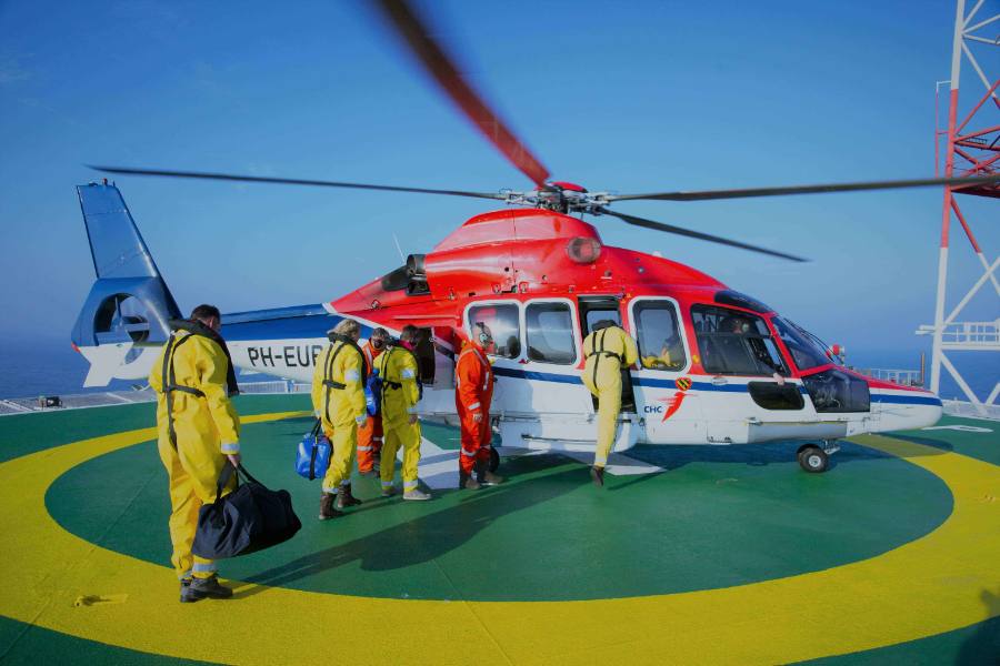 Offshore workers next to a helicopter on a platform